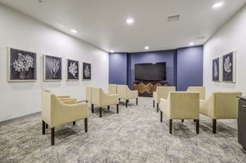 A large room with chairs and a television in the center of it